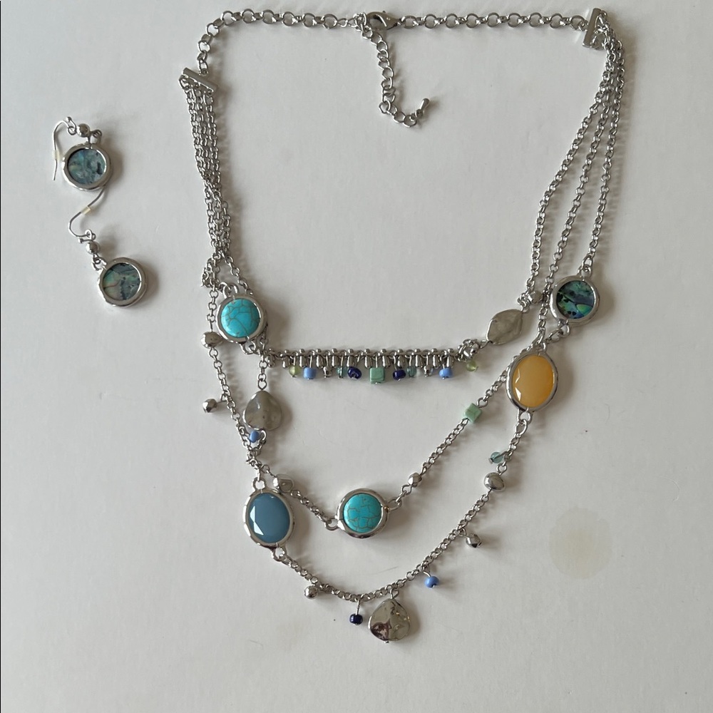 Necklace is silver-tone 3-strand w turquoise blue stones and colored charms.
